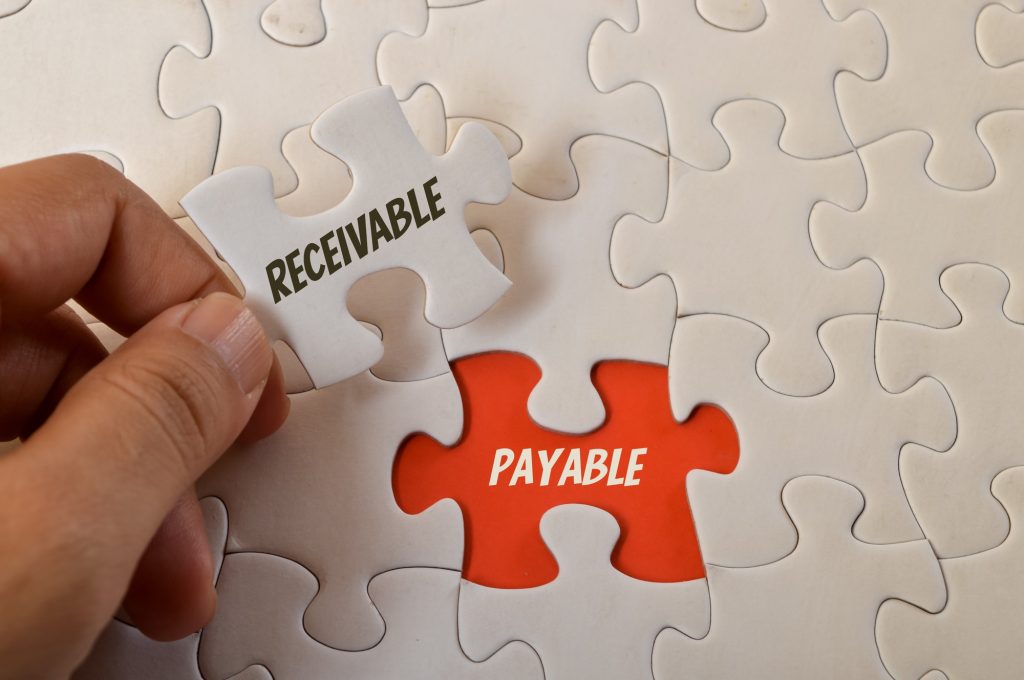 Jigsaw puzzle with text RECEIVABLE and PAYABLE.